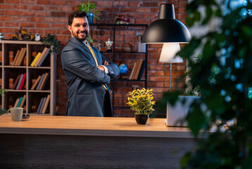 Indian businessman standing in style at desk, confident leader showing pride and authority