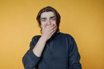 Person shows surprise and shock against a bright yellow background during an unexpected moment