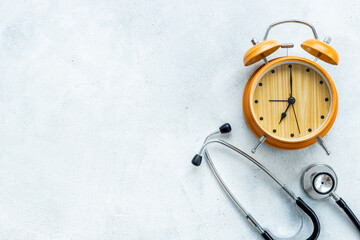 Stethoscope and vintage alarm clock, top view. Time for medical checkup
