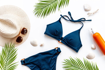 Bikini swimsuit with and palm leaves with beach accessories. Flat lay, top view