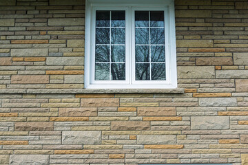 White wooden framed window on brick wall facade of a house