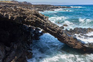 Volcanic arch with crashing waves