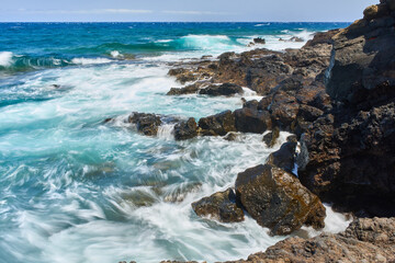 Waves hitting volcanic shoreline