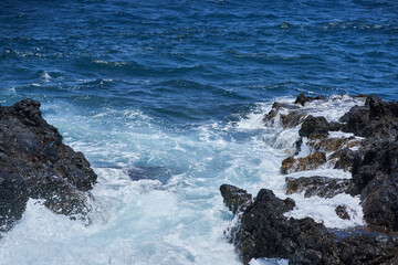 Waves hitting volcanic shoreline