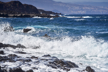 Waves hitting volcanic shoreline
