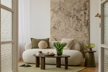 Cozy living space with white sofa, abstract wall painting, green tulips in glass vase, and...