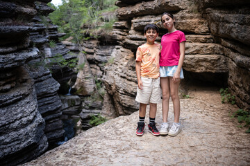 Kids exploring breathtaking canyon with waterfall