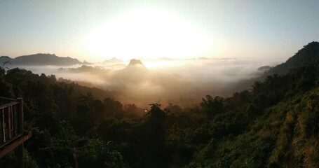 Serene Landscape with Morning Mist and Sunlight over Mountains