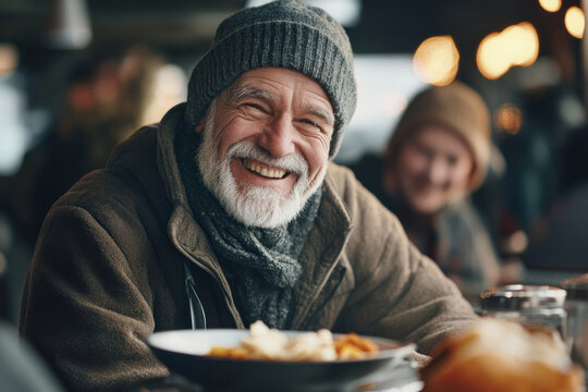 elderly homeless man in cozy winter clothing smiling joyfully in warm community center. winter leisure, comfort, happiness. charity promotion and social awareness campaign. - Powered by Adobe