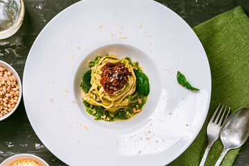 Fituccine pasta with balanese sauce and basil and pine nuts with pesto sauce. Top view.