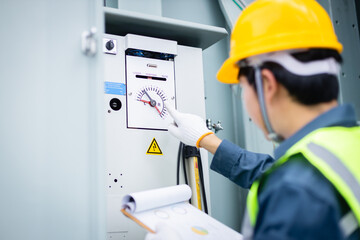 Engineer is working on high voltage power substation performing inspection and check of electrical infrastructure to ensure safety and proper operation