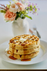 fresh buttermilk and almond flour waffles topped with butter and maple syrup
