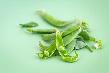 Ripe green peas in open pods on table