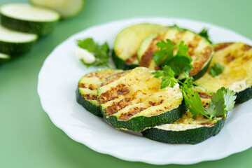 Textured fried zucchini on a plain green background