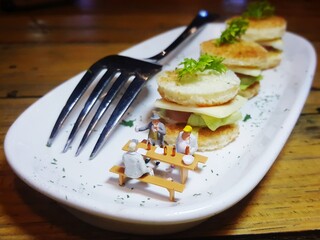 Mini toy of action figure at food table with blurred background. Miniature and food photography concept design.