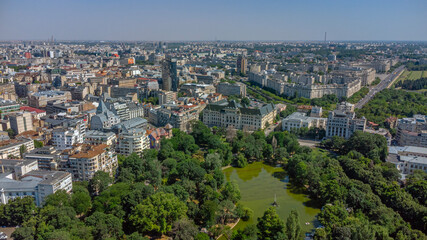 Panoramic aerial view of city with green park and lake.
