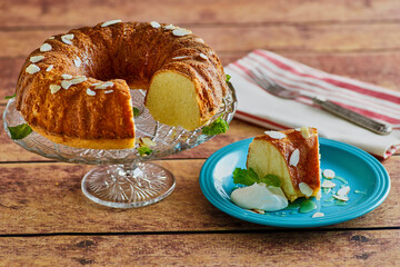 almond bundt cake topped with sliced almonds and whipped cream