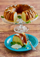 almond bundt cake topped with sliced almonds and whipped cream