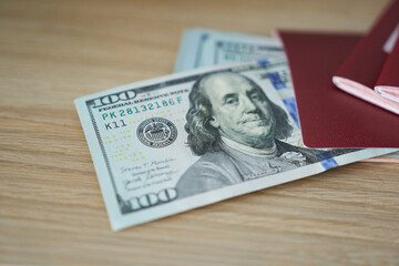 Dollars in red passport on wooden background. Selective focus.