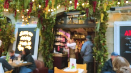 Restaurant patrons and waiters in a busy French restaurant during lunchtime. Saint-Malo, Brittany, France. Out of focus.