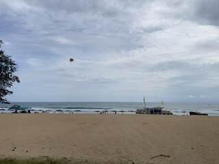 Parasailing on the beach with cloudy sky in the background.