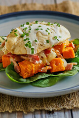 roasted chicken breast with a cream sauce, sautéed sweet potatoes with onion, and a spinach salad topped with fresh chives