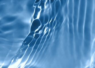 Abstract blurred shades of blue water background. Light and shadow ripples or splashes surface of water texture. Water waves with shining and reflection pattern photography for​ design artwork.