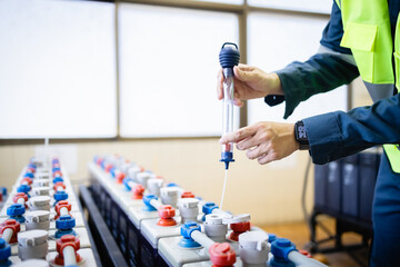 Technician performs maintenance on backup battery system ensuring reliable power supply and...