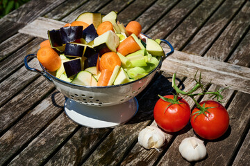 Fresh washed vegetables resting on wooden table in garden sunlight