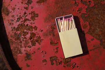 matchbox on red old iron background. matches with pink sulfur