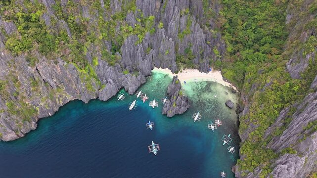 Bird's-eye survey of the Secret Lagoon, Jiji's Beach, with boats in Miniloc Island, in Philippines