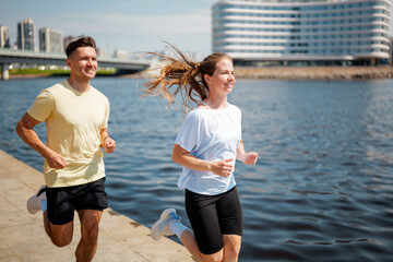 Joyful joggers embrace the morning sun by the riverside while enjoying a refreshing run