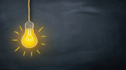 The illuminated light bulb shining brightly on a chalkboard background.