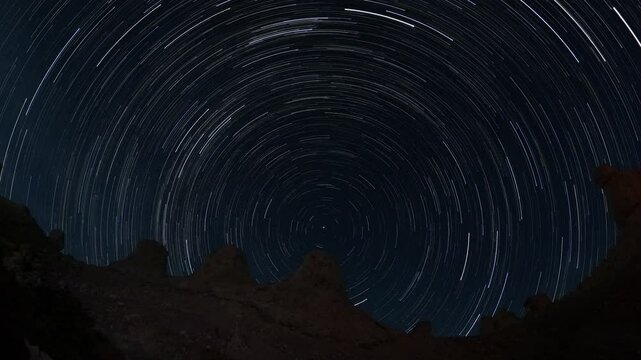 A timelapse of startrails over rocky pinnacle outcrops in the desert at night