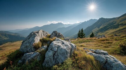 Scenic summer mountain landscape with rocky foreground and distant hazy peaks under midday sun