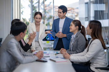A group of people are sitting around a table in a conference room