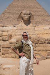 Tourist smiling with the great sphinx of giza and great pyramid in the background