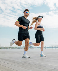 Couple enjoys a morning jog along the waterfront in bright sunny weather