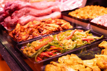 Meat department of store sells chicken meat and vegetables marinated with addition of spicy seasoning