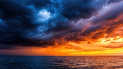 Dramatic sunset over the ocean with dark storm clouds gathering on the horizon