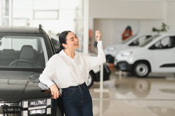 Lady in a car salon. Woman buying the car. In a white shirt