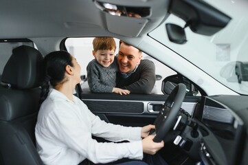Happy family buying a new car at the car showroom