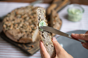 Spreading Herb Butter on Homemade Seeded Buckwheat Bread Slice