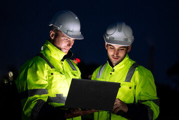 Engineer worker watching work monitor on laptop and checking for quality control at construction...
