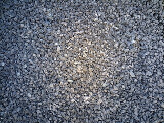 A close-up image showing a uniform spread of small, gray crushed stones used for paving.