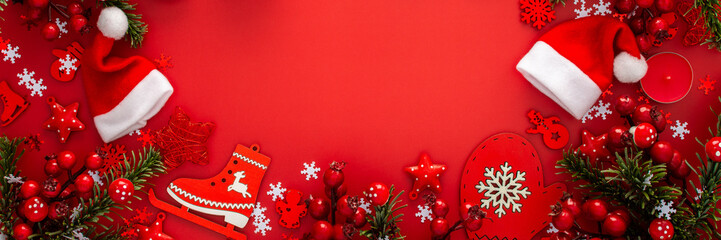 Red Christmas background with fir branches and red Christmas tree toys and balls and candles, banner