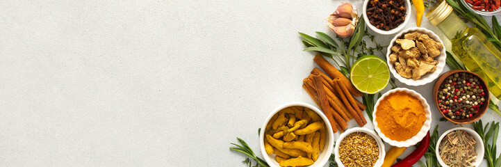 A wide selection of cooking spices and herbs on a gray background, perfect for adding depth to any dish, top view and copy space, banner