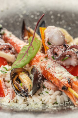 A close-up of gourmet seafood risotto featuring mussels, shrimp, octopus, parmesan, and fresh...