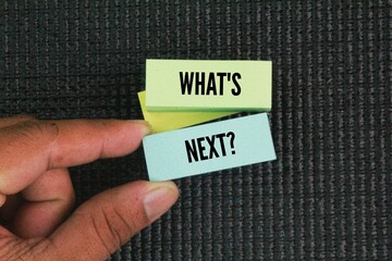 Colored paper with the word question What's Next? next step concept. coming immediately after the...