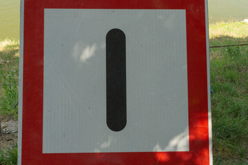 Number one traffic sign with red border and black vertical line on white background, concept of...